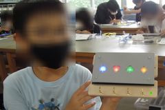 完成した作品をもってポーズする子供の様子